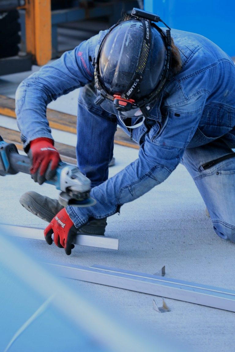 グラインダーでパネルを加工する作業者